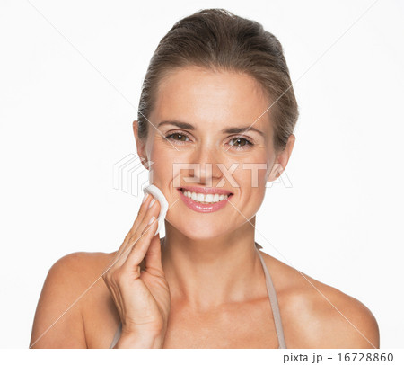 Happy woman using cotton pad to remove makeup 16728860