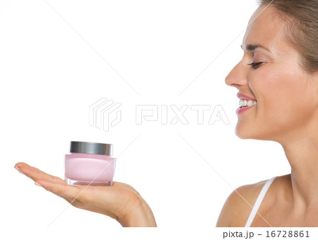 Profile portrait of smiling young woman showing creme 16728861