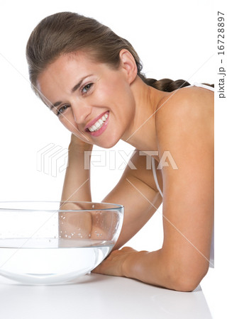Profile portrait of young woman with glass bowl with water 16728897