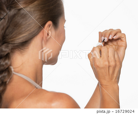 Young woman using nail polish . rear view 16729024