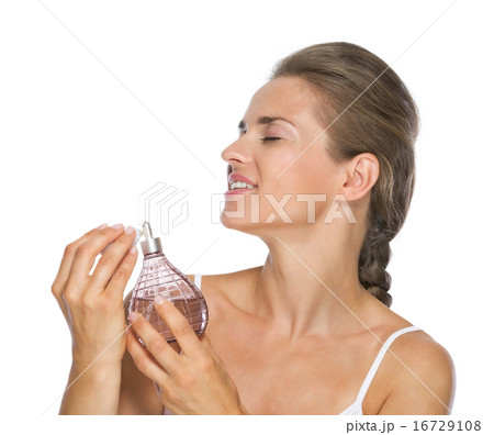 Young woman applying perfume 16729108