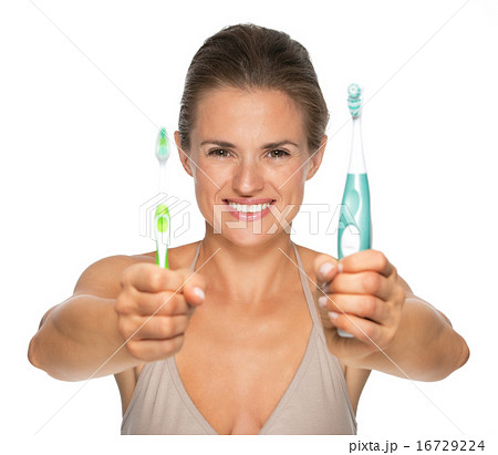 Happy young woman showing old and electric toothbrush 16729224