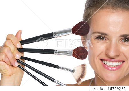 Young woman showing makeup brushes 16729225