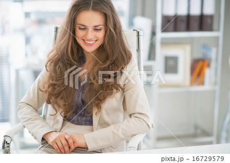 Portrait of happy business woman sitting in office Portrait of happy business woman sitting in office 16729579
