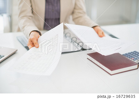 Closeup on clueless business woman with documents 16729635