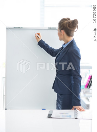 Business woman writing on flipchart 16729909
