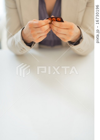 Closeup on business woman taking pill from blister pack 16730196