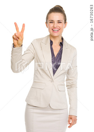 Smiling business woman showing victory gesture 16730263