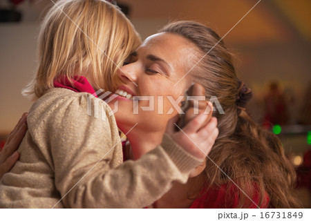 Portrait of baby hugging mother in christmas decorated kitchen 16731849
