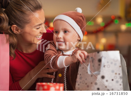 Happy mother and baby checking christmas shopping bags 16731850