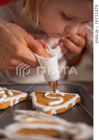 Closeup on mother and baby decorating homemade christmas cookies Closeup on mother and baby decorating homemade christmas cookies 16731878
