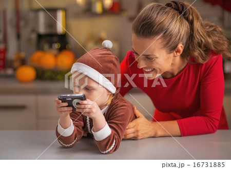 Happy mother and baby looking photos in camera 16731885
