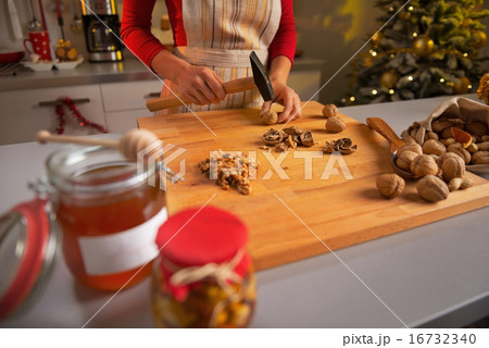 Closeup on young housewife chopping walnuts in christmas decorat 16732340