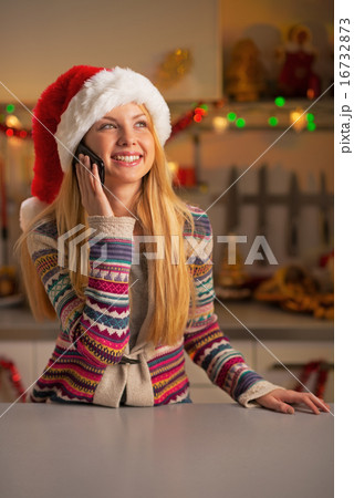 Happy teenager girl in santa hat talking cell phone in christmas 16732873