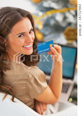 Portrait of smiling young woman with credit card using laptop in Portrait of smiling young woman with credit card using laptop in 16732983