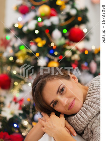 Portrait of dreaming young woman near Christmas tree Portrait of dreaming young woman near Christmas tree 16733098