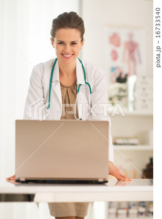 Portrait of happy medical doctor woman with laptop in office 16733540