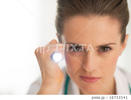 Portrait of doctor woman using flashlight 16733541
