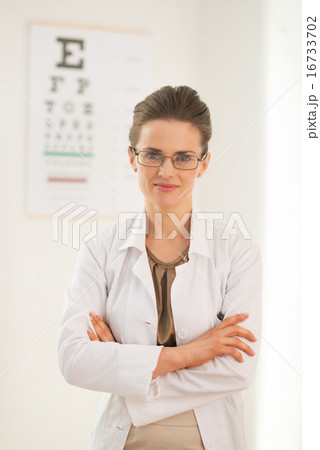 Portrait of ophthalmologist doctor woman in front of snellen cha 16733702