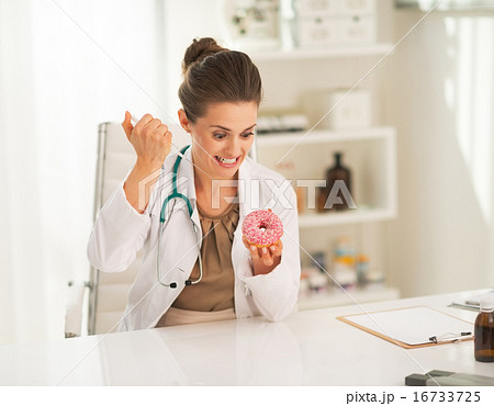 Angry doctor woman making injection into donut 16733725