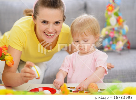 Happy mother and baby making Easter decorations 16733998