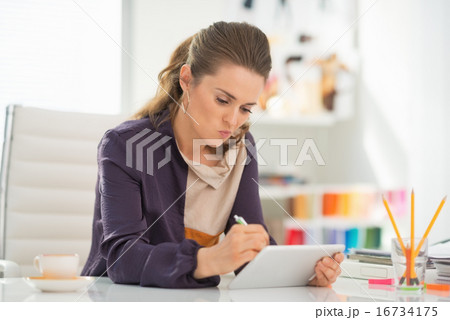 Fashion designer working on tablet pc in office Fashion designer working on tablet pc in office 16734175