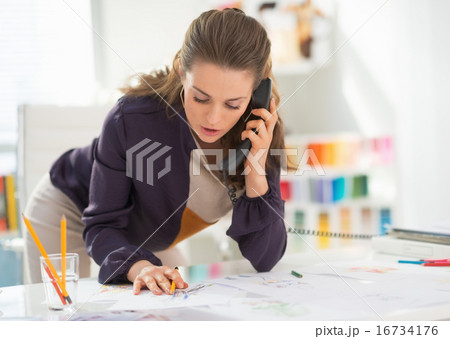 Fashion designer talking phone at work Fashion designer talking phone at work 16734176