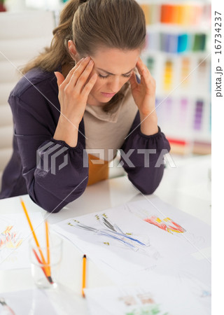 Portrait of stressed fashion designer in office 16734237