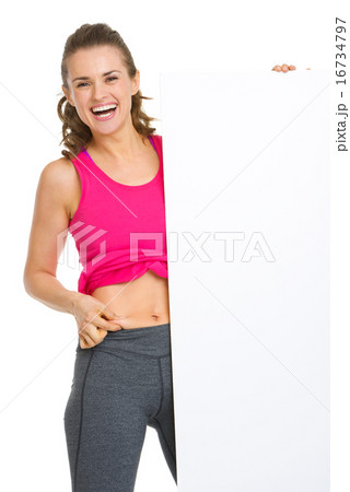 Happy fitness young woman checking body fat and showing blank bi Happy fitness young woman checking body fat and showing blank bi 16734797