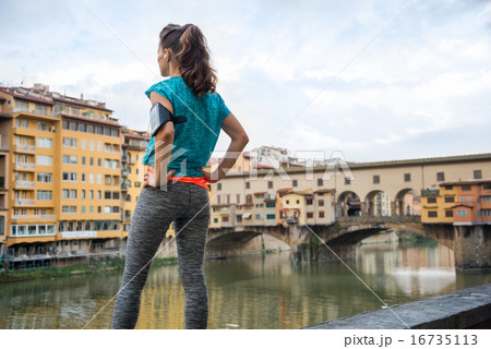 Fitness woman standing in front of ponte vecchio in florence, it Fitness woman standing in front of ponte vecchio in florence, it 16735113