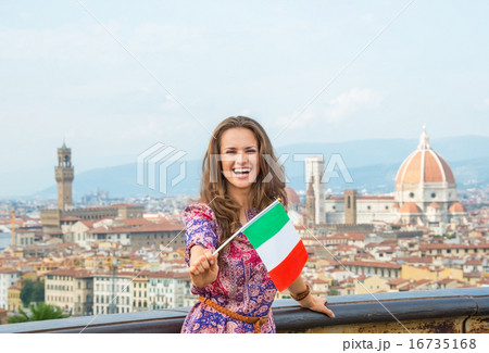 Happy young woman showing flag against panoramic view of florenc Happy young woman showing flag against panoramic view of florenc 16735168