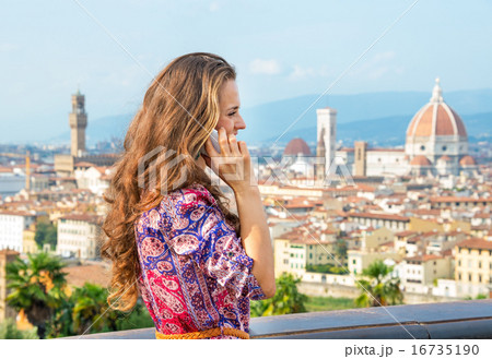 Young woman talking cell phone against panoramic view of florenc Young woman talking cell phone against panoramic view of florenc 16735190
