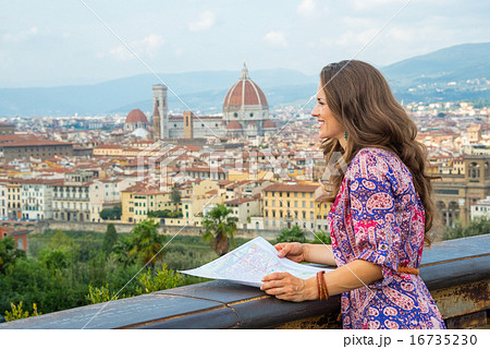 Young woman with map against panoramic view of florence, italy 16735230