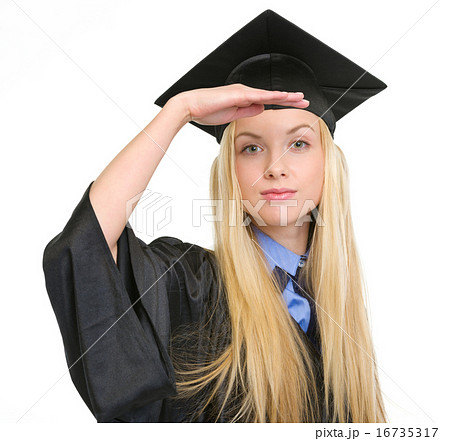 Young woman in graduation gown looking into distance 16735317
