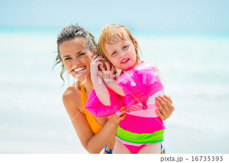 Portrait of mother and baby girl listening sound of sea in shell Portrait of mother and baby girl listening sound of sea in shell 16735393
