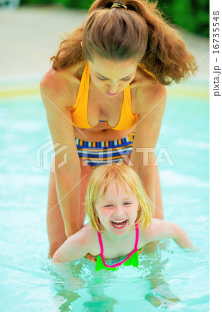 Mother and baby girl playing in swimming pool 16735548