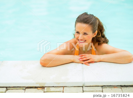 Portrait of happy young woman in pool looking on copy space 16735824