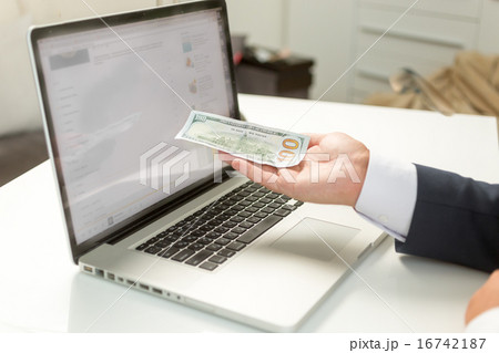 businessman giving banknote to computer businessman giving banknote to computer 16742187