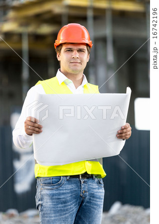 foreman reading blueprints on building site 16742196