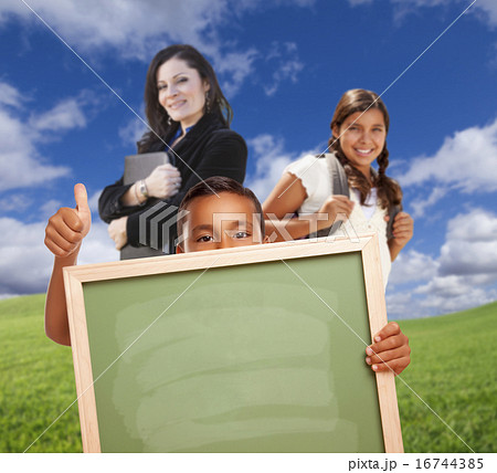 Hispanic Boy In Grass Holding Blank Chalk Board 16744385