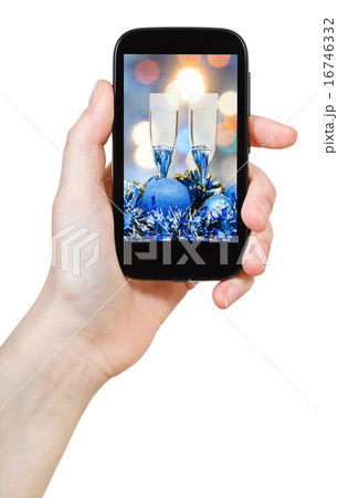 hand holds cellular phone with Xmas still life hand holds cellular phone with Xmas still life 16746332