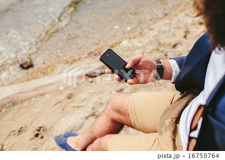 American Bearded Man using phone near the river 16750764