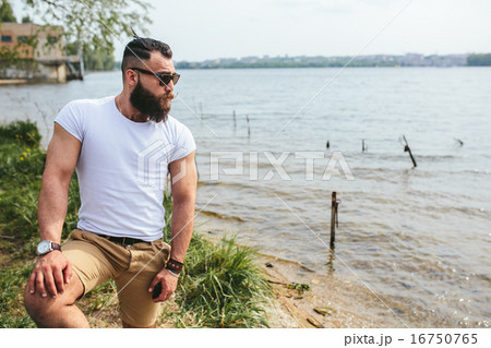 American Bearded Man looks on the river bank 16750765