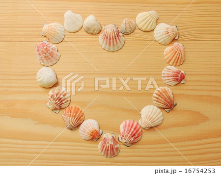 Heart of seashells on wooden texture. 16754253