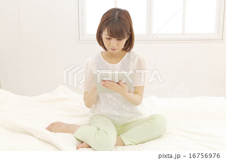 ベットでタブレットを見る女性 16756976