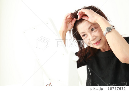 鏡を見る60代女性 16757632