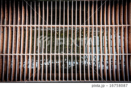 dirty and old aligned manhole cover 16758087