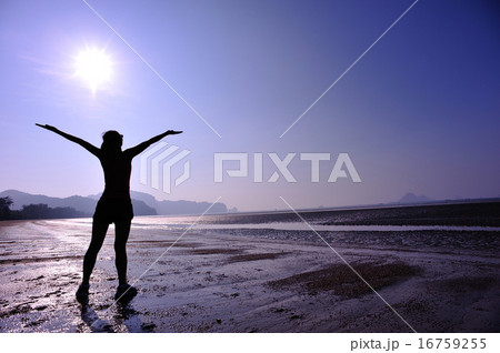 cheering young woman open arms on sunrise beach 16759255