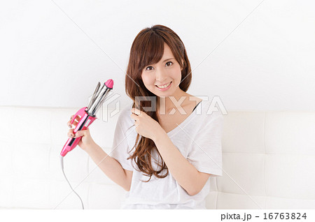 ヘアアイロンを使う若い女性 ヘアアイロンを使う若い女性 16763824