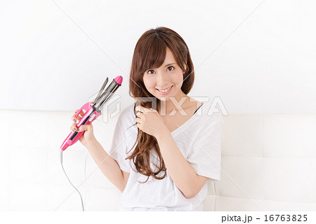 ヘアアイロンを使う若い女性 ヘアアイロンを使う若い女性 16763825